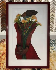 A framed picture of flowers in a vase.