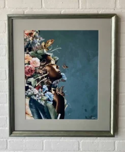 A painting of flowers and animals in a silver frame.