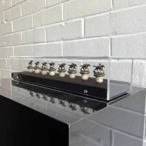 Acrylic Box, A display case with ten small clocks on top of it.