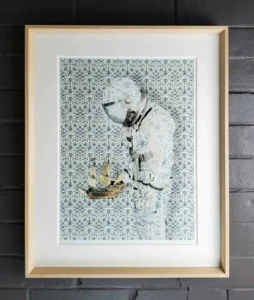 A framed picture of a person holding something in his hand.