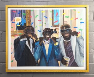 three men in suits and sunglasses at a party smiling for the painter. There is exaggerated confetti falling. Two men are holding fingers at the corner of their mouths - the last man has one finger at his left corner mouth but holds a transparent cup with beer in it. There are people seated in the background on an ivory sofa. The left most figure has a gold grill on his teeth. This is framed in a bright gold polka dotted frame.