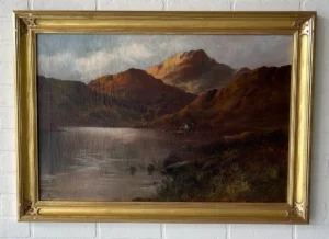 A painting of mountains and water in a frame.