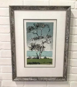 A framed picture of a tree with a sky background