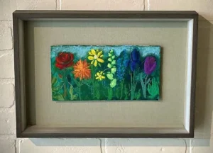 A painting of flowers in a frame on the wall.