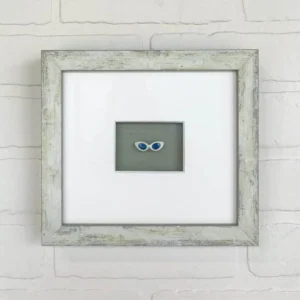 A picture frame with two pairs of glasses on it.