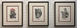 Banksy, A framed drawing of a man 's face with red lips.