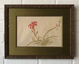 A painting of a flower on paper in a frame.