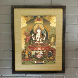 A painting of the buddha in a frame on a wall.