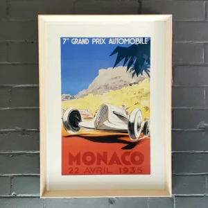 A framed poster of an old racing car.