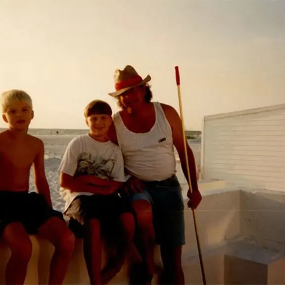 SSweb006 (1) A man and two boys are sitting on the beach